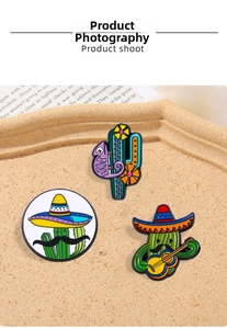 Macro view of cartoon cactus and chameleon enamel pins on a cork display board