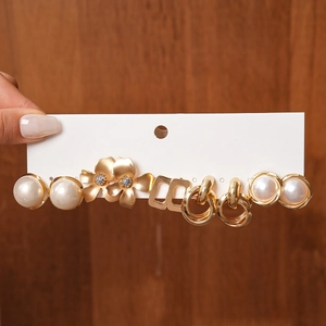 Detail of 6-pair gold earring set with faux pearls, floral designs, and geometric shapes