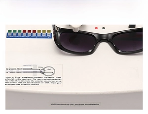 Detail view of black square sunglasses on UV400 test device showing lens protection level
