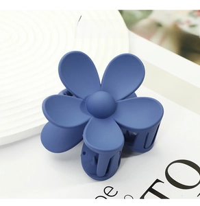 Detailed close-up of a blue matte flower hair claw clip with a minimalist five-petal design