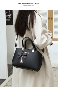 Detail of black PU leather shell bag with bow decoration and star metal charm