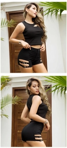 Dettaglio di pantaloncini neri a vita alta con fibbie metalliche laterali e cinturini
