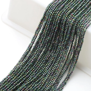 Macro shot of 2mm faceted glass beads in iridescent green-black for jewelry making