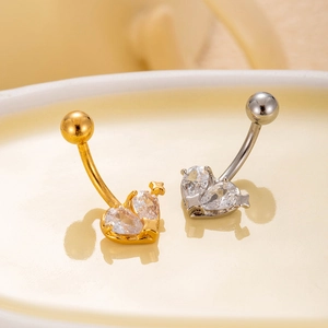 Detailed macro view of heart-shaped belly rings with silver and gold finishes and cubic zirconia