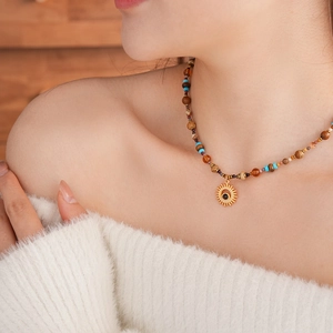 Detailed view of beaded sun pendant necklace worn on neck with vintage bohemian style