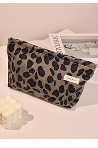 Close-up of leopard print corduroy makeup bag with H & R BAG label on a white table