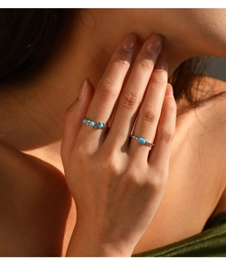 Close-up of dual silver S925 rings with turquoise stones worn on female fingers