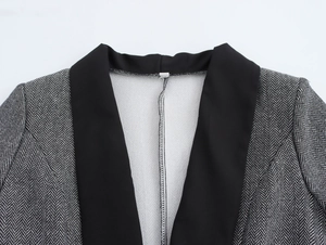 Detail of grey houndstooth blazer showing black contrast lapel and stitching quality