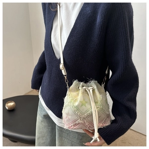 Detail of denim bucket bag with drawstring closure and frayed edge star print fabric