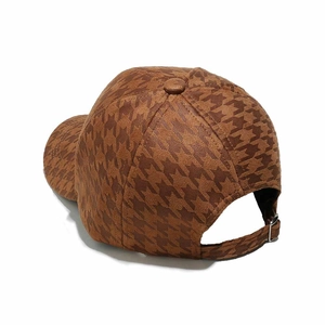 Detail of houndstooth baseball cap showing brown fabric texture and metal back buckle