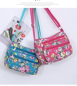 Detail view of floral crossbody bags with multiple zippers in blue and pink colors