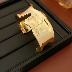 Bracelet manchette doré irrégulier minimaliste avec bords ondulés et finition miroir