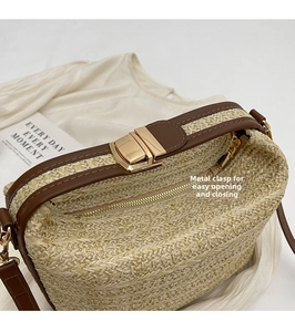 Dettaglio della chiusura a scatto in metallo dorato e zip di una borsa in paglia intrecciata