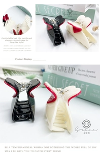 Detail of butterfly hair claws in black and cream with red accents and firm grip teeth