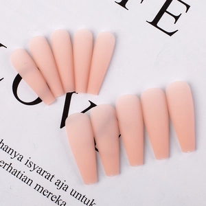 Detailed flat lay of matte pink long coffin press-on nails arranged on paper