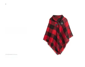 Close-up of buffalo check poncho showing toggle button and fringe hem detail