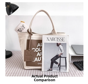 Detail view of large canvas tote bag with brown leather patch on a home workspace desk