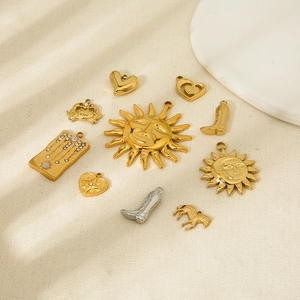 Flat lay of gold and silver charms including cowboy boots and sun motifs for jewelry making