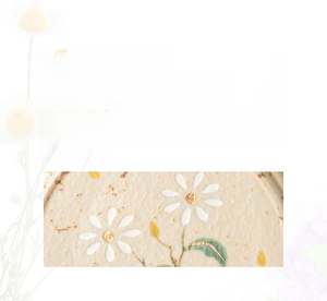 Close-up of hand-painted daisy pattern and gold-rimmed ceramic espresso tea cup