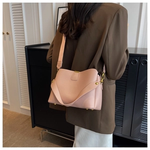 Detail of pink lychee leather tote bag featuring gold hardware and wide shoulder strap