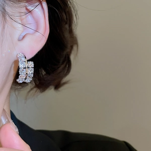 Gros plan sur les créoles doubles en C serties de zircons brillants en argent