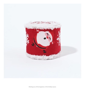 Detail view of red Christmas ribbon with white plush edges and Santa Claus pattern