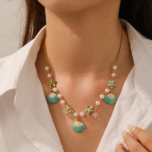 Detail of beaded beach necklace with colorful starfish and shells on a white shirt