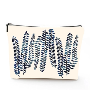 Detail of linen toiletry bag with blue leaf pattern and secure metal zipper closure