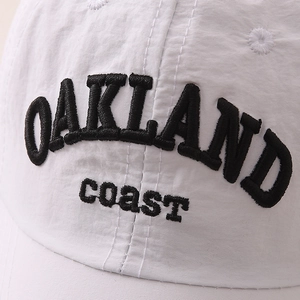 Detailed close-up of Oakland embroidery on white quick-dry cotton baseball cap
