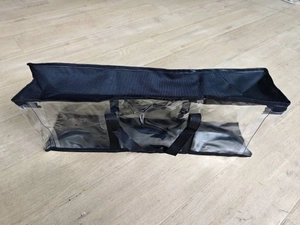 Macro shot of long transparent PVC storage bag with black non-woven fabric handles