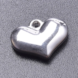Macro shot of polished silver heart pendant with smooth mirror finish and hanging hole