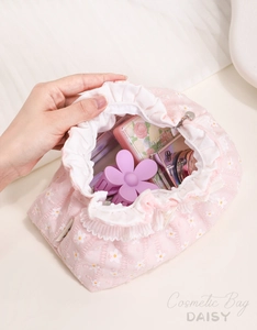 Pink daisy floral cosmetic bag with ruffled edges showing spacious interior storage