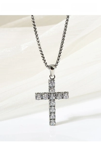 Close-up of titanium steel cross pendant necklace with zircon stones on white silk