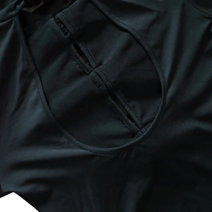 Détail du design découpé sexy et du tissu noir élastique de cette robe à manches longues