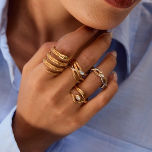 Minimalist snake shaped gold and silver rings with shell inlay worn by a female model