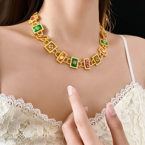 Close-up of vintage gold necklace with green and brown enamel links and small gems