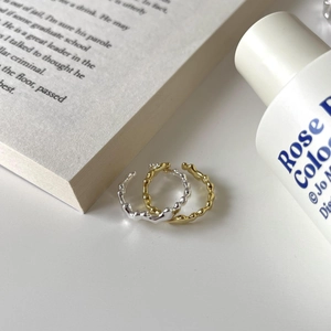 Close-up of irregular wavy S925 sterling silver rings in gold and silver finishes