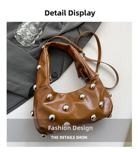 Close-up of brown PU leather hobo bag with silver rivet details and adjustable strap