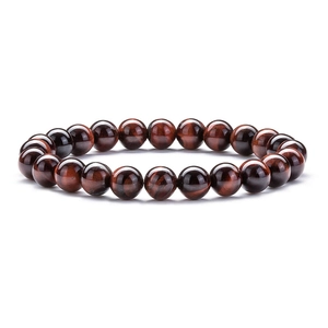 Macro detail of red tiger eye stone bracelet with smooth round beads on white background