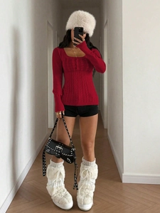 Close-up of vibrant red knit sweater featuring intricate cable weave and square neckline