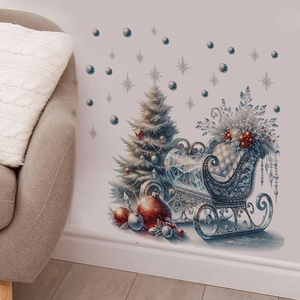 Détail de stickers sapin et traîneau de Noël sur mur blanc près d'un canapé gris