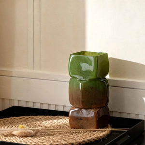 Detail of artistic geometric square vase featuring a green to brown gradient glossy finish