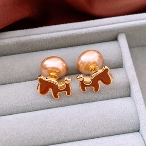 Detailed macro view of 18K gold plated horse stud earrings with elegant pink pearls