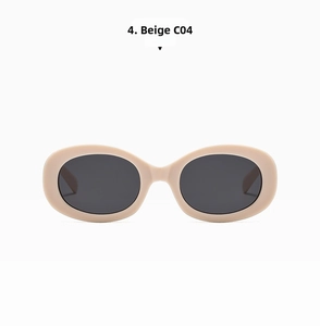 Detail view of oval beige sunglasses with three-pin accents and dark tinted lenses