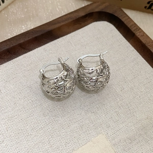 Detail of silver geometric flower earrings with intricate hollow mesh texture and pearls