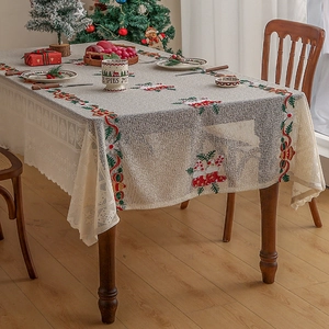 Close-up of Christmas tablecloth featuring festive embroidery and delicate lace edges