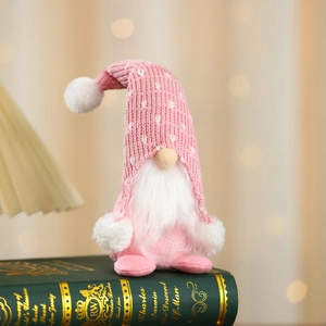 Macro detail of sitting Christmas gnome with pink heart-pattern knitted hat and plush beard
