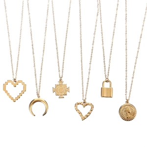 Collection détaillée de pendentifs dorés en acier 304 avec motifs cœur, croix et pièces
