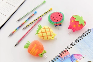 Dettaglio di simpatici tappi per penne in peluche a forma di fragola e ananas