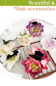 Detailed view of assorted fabric rose hair claws in various colors on a display tray